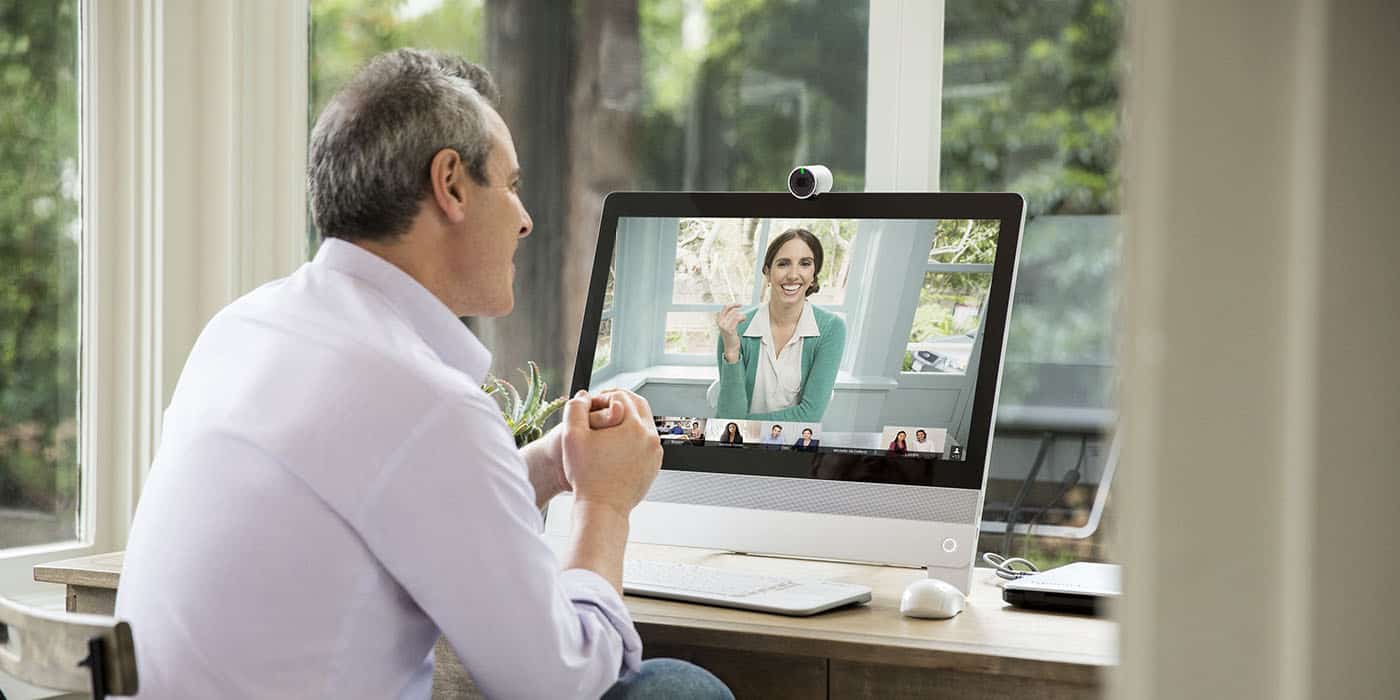 Here’s our top tips on effectively managing a remote team when a team takes on a new challenge - the experience of working together remotely. Two people talking face to face on a remote meeting.